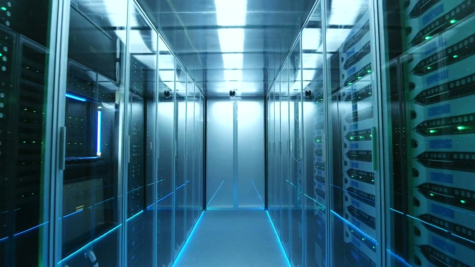 Data center aisle with ceiling camera coverage.