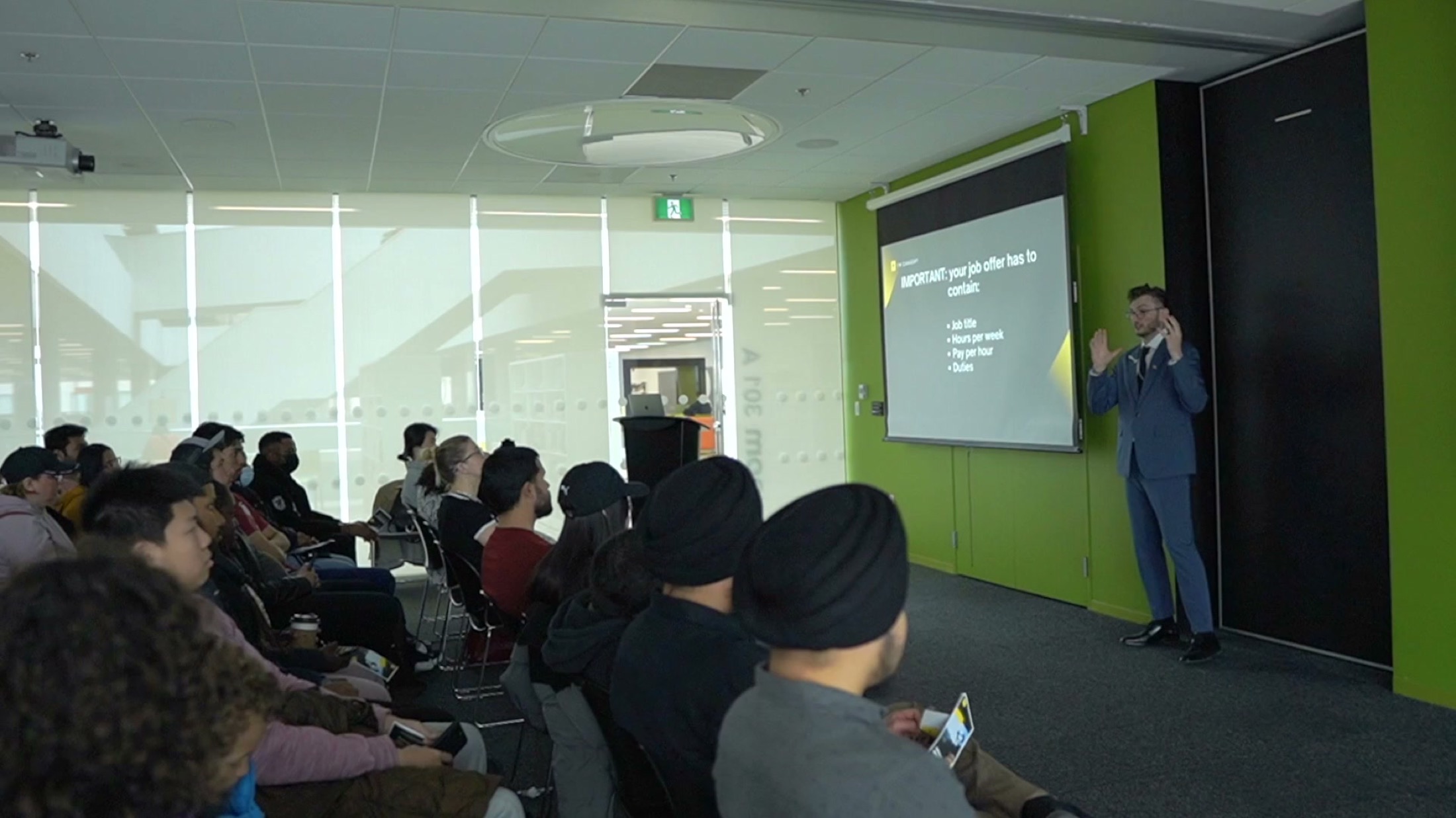 Presenter delivering an internal briefing to a seated audience.